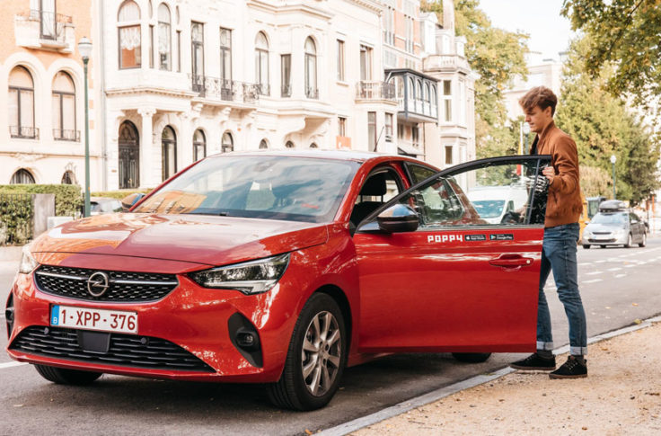 man rents and opens a red poppy carsharing car
