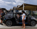 A Miocar parked at home is charging. The owners are unloading the car