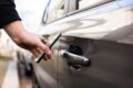 A car sharing customer tries to open a shared vehicle with their smartphone at the start of their rental.