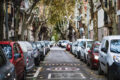 A tree-lined street with parked cars on both sides, offering ample street parking, making it a convenient spot for car share enthusiasts looking for easy curb access.